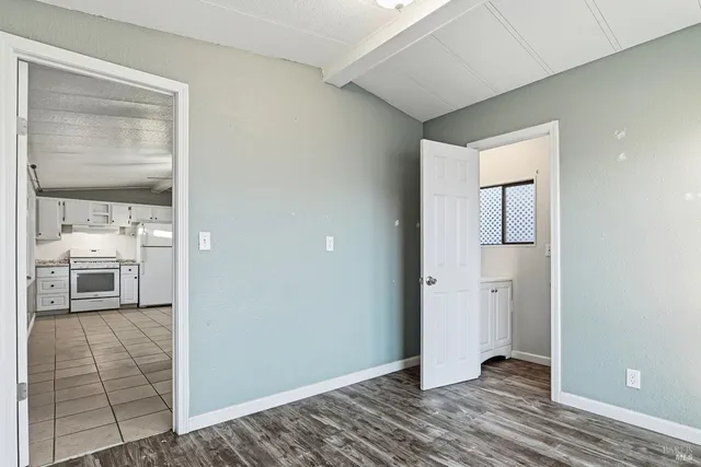 a view of a hallway with wooden floor and a living room