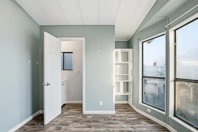 a view of a hallway with wooden floor and a living room