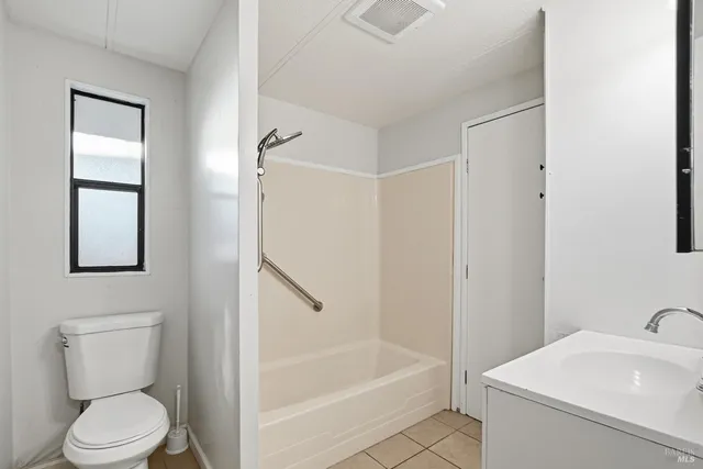 a white toilet sitting next to a bath tub