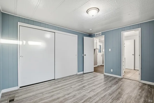 an empty room with wooden floor and mirror