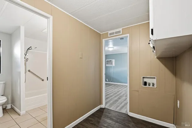 a view of a hallway with wooden floor and closet