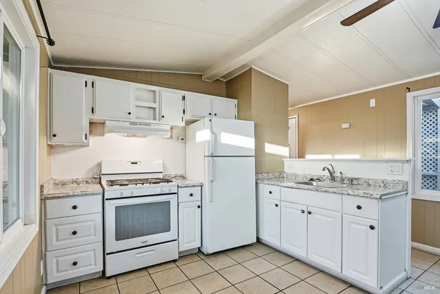 a kitchen with cabinets stainless steel appliances and sink