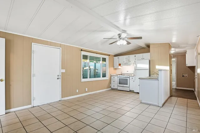 a large white kitchen with a stove a sink dishwasher and a refrigerator