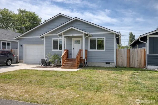 a view of a house with backyard and chairs