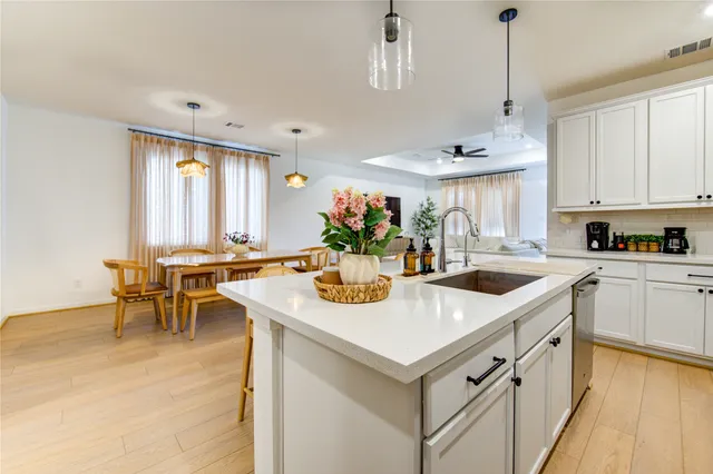 a kitchen with stainless steel appliances granite countertop a sink a stove and a dining table