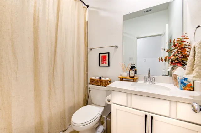 a bathroom with a sink vanity mirror and toilet