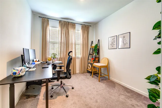 a view of a workspace with furniture and a window