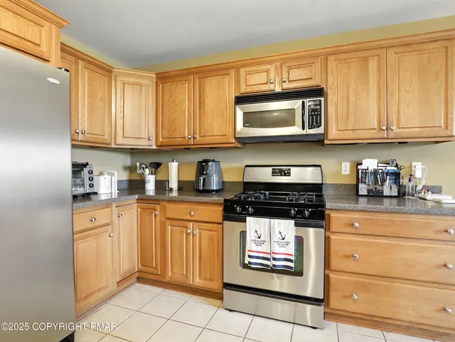 a kitchen with stainless steel appliances granite countertop a stove a sink and a refrigerator