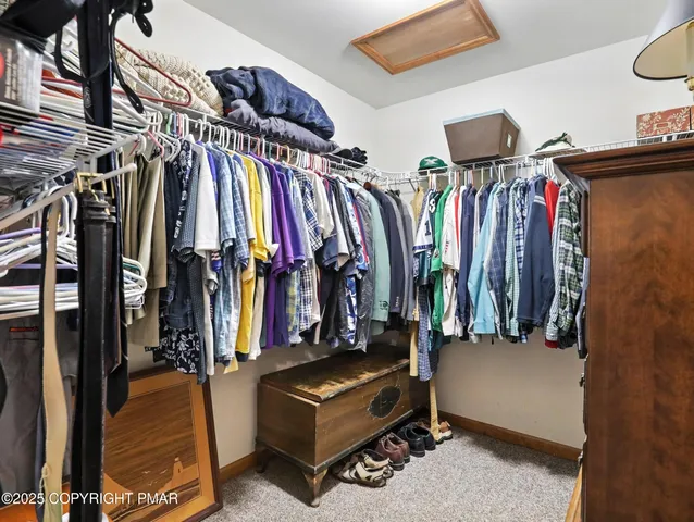 a view of walk in closet with clothes and shoes