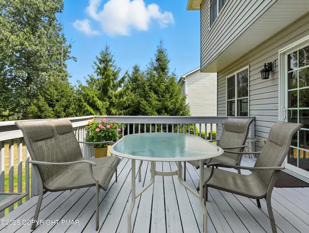 a balcony with wooden floor table and chairs