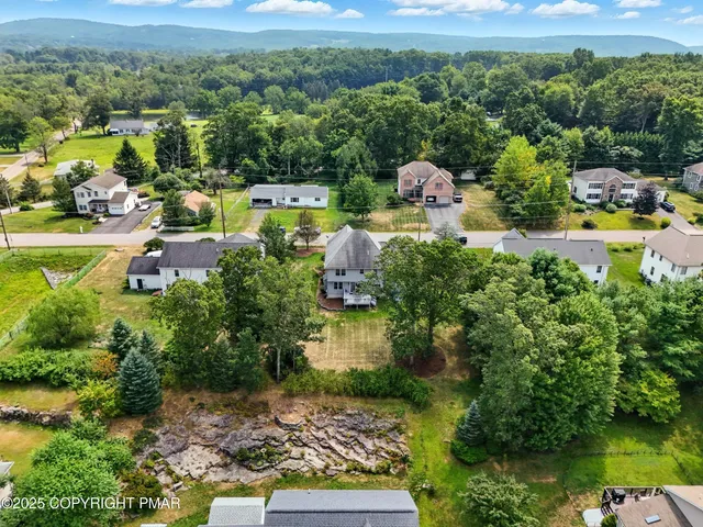 an aerial view of a house with a yard basket ball court and outdoor seating