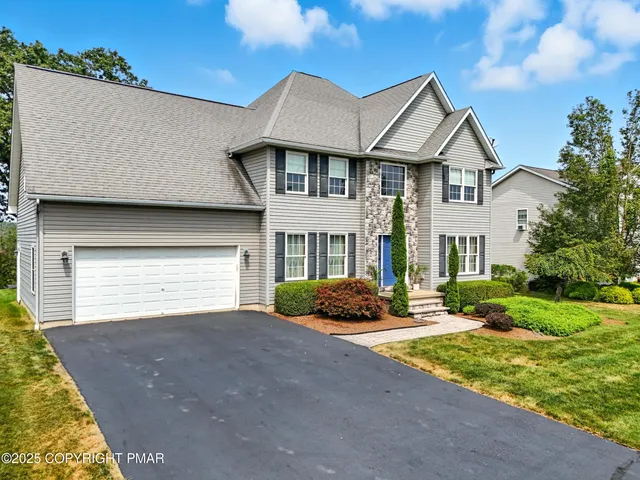 a front view of a house with garden and parking