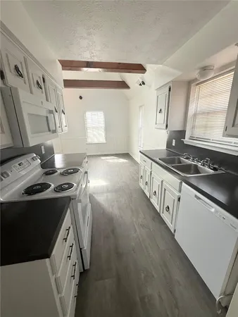 a kitchen that has a sink a stove and a window