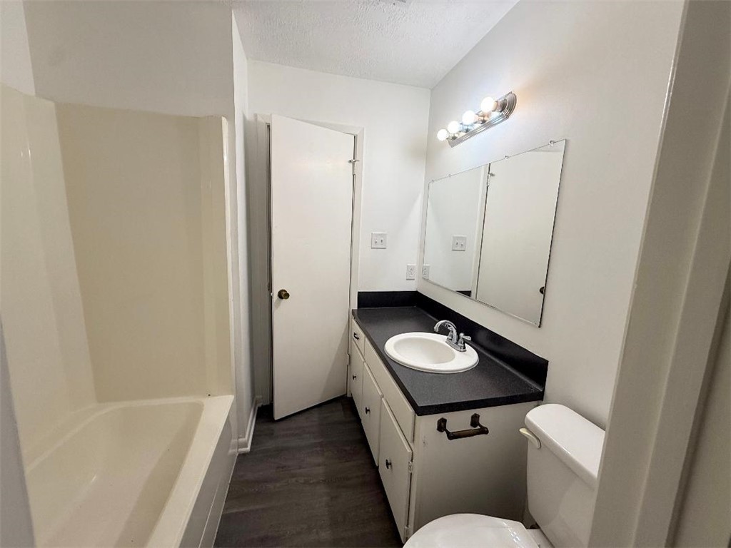 4211 Marsh Street Bryan, TX 77803 - Photo 10 of 13 a bathroom with a granite countertop sink a toilet and bathtub