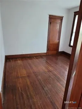 a view of an empty room and wooden floor