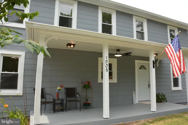 a front view of a house with outdoor seating and a potted plant