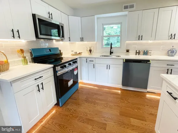 a kitchen with a sink stove and microwave