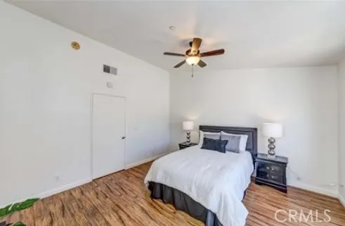 a bedroom with a bed and wooden floor