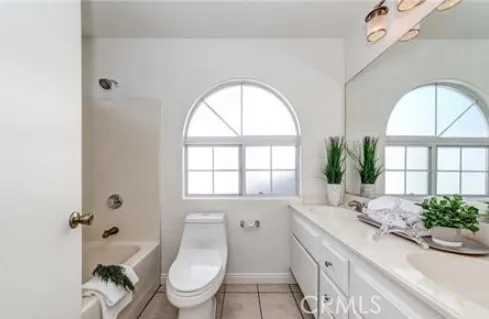 a spacious bathroom with a granite countertop toilet a sink and a large mirror