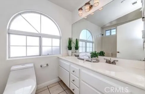 a bathroom with a granite countertop sink a large mirror a vanity and a large window