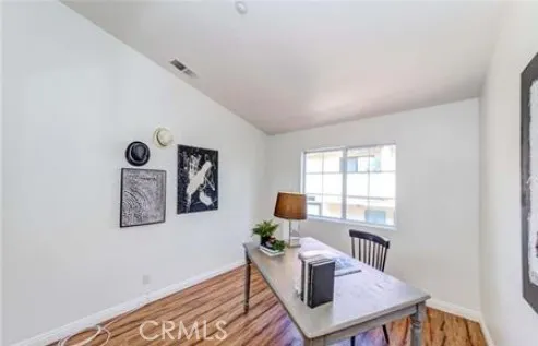 a view of a workspace with furniture and a window