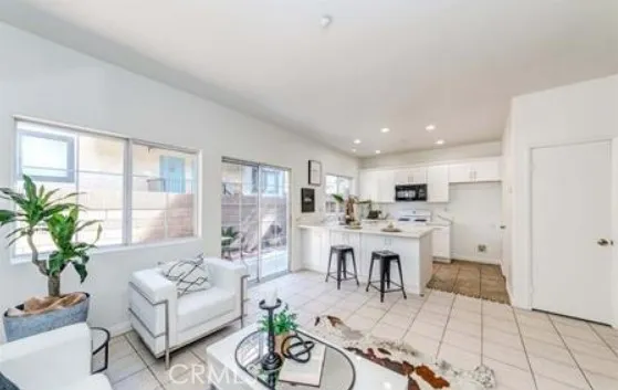 a living room with furniture a dining table and a large window