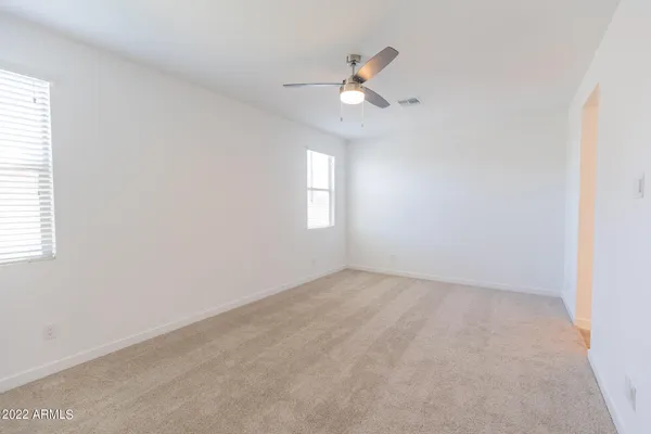an empty room with windows and fan