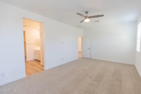 an empty room with closet and a ceiling fan