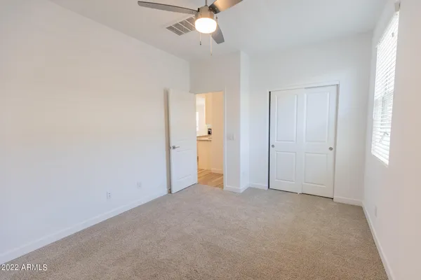 an empty room with a ceiling fan and a window