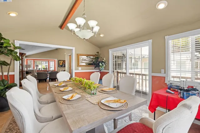 a view of a dining room with furniture a chandelier and wooden floor