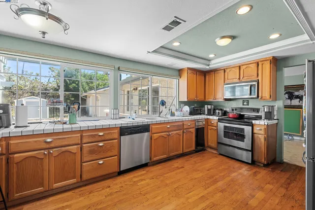 a large kitchen with stainless steel appliances granite countertop a stove and a sink