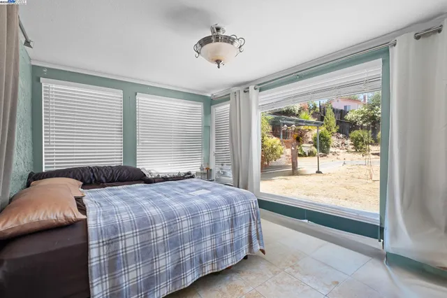 a bedroom with a bed and a large window