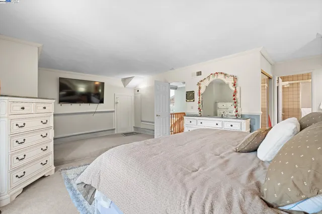 a spacious bedroom with a bed a television and dresser