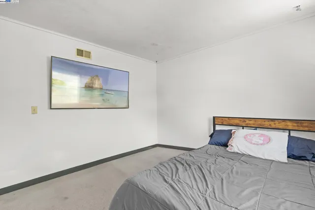 a bedroom with a bed and a wall painting