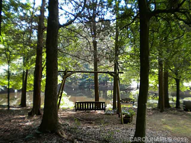 4604 Morgan Mill Road Monroe, NC 28110 - Photo 6 of 9 a view of a wooden bench under a large tree