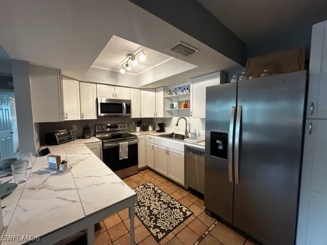 a kitchen with a refrigerator microwave and stove top oven