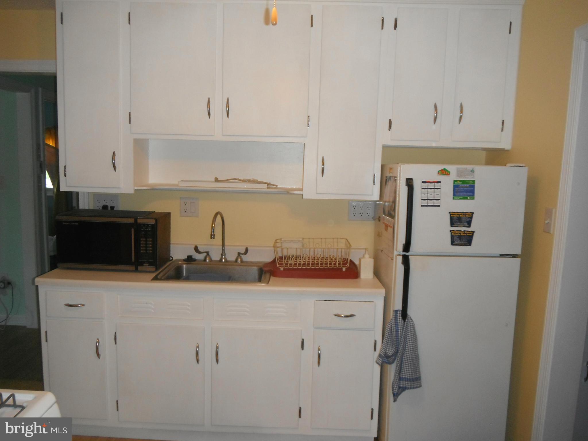 12308 Veirs Mill Road Silver Spring, MD 20906 - Photo 17 of 25 a kitchen with stainless steel appliances granite countertop a sink a stove and white cabinets