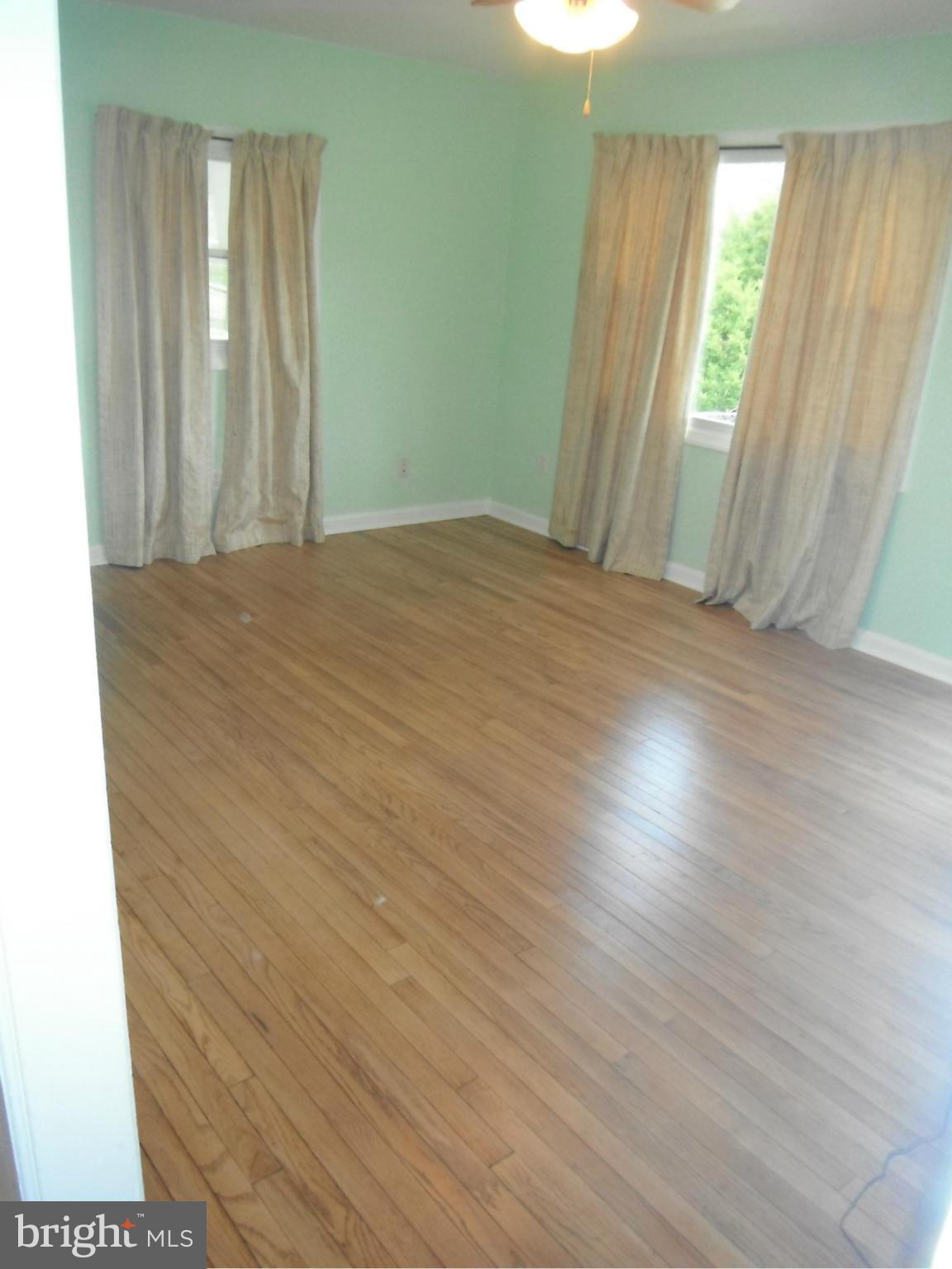 12308 Veirs Mill Road Silver Spring, MD 20906 - Photo 21 of 25 an empty room with wooden floor and windows