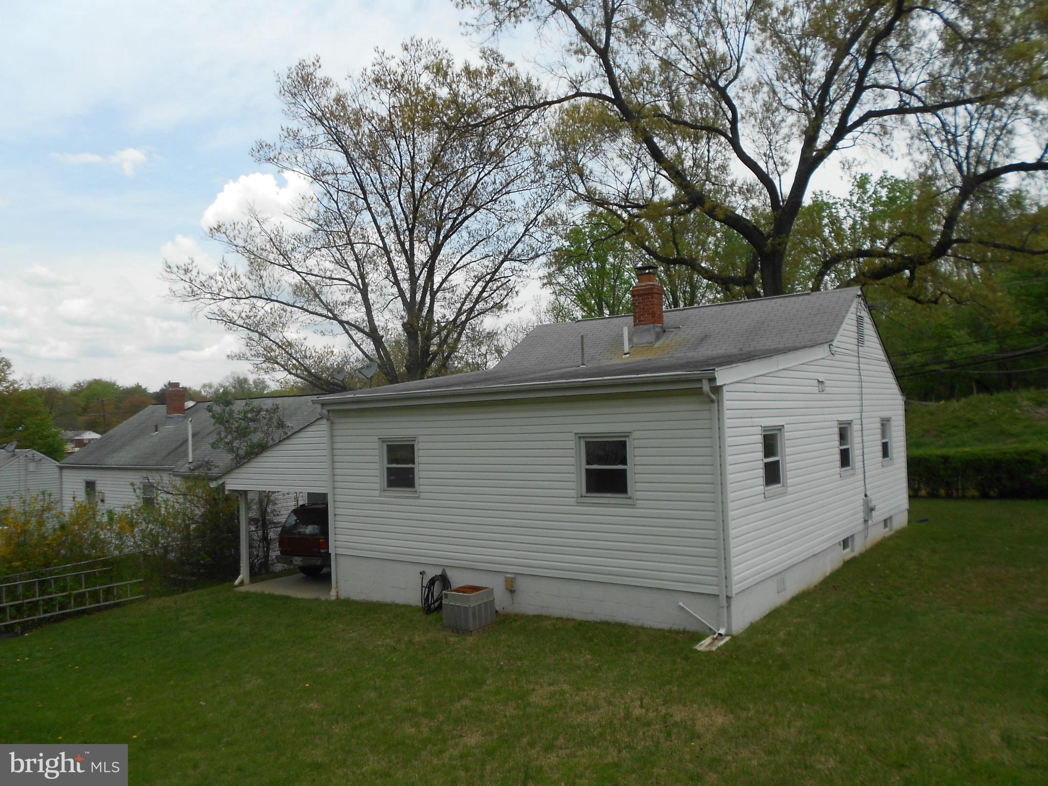 12308 Veirs Mill Road Silver Spring, MD 20906 - Photo 5 of 25 a view of a white house next to a yard with big trees