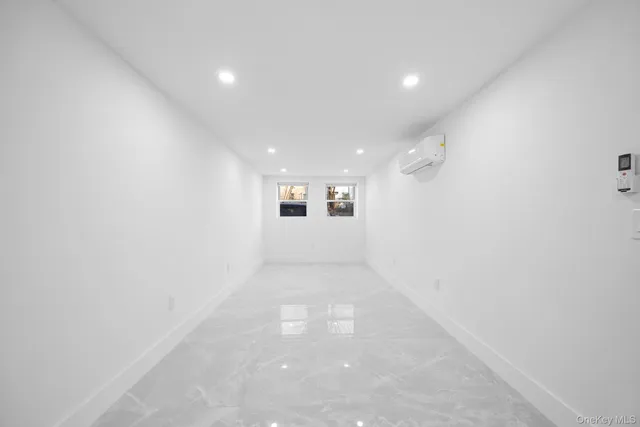 a view of a big room with wooden floor and windows