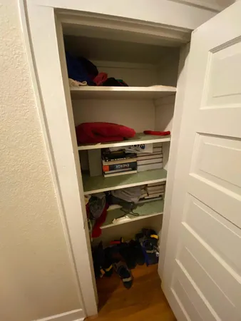 a view of walk in closet with clothes and shoes