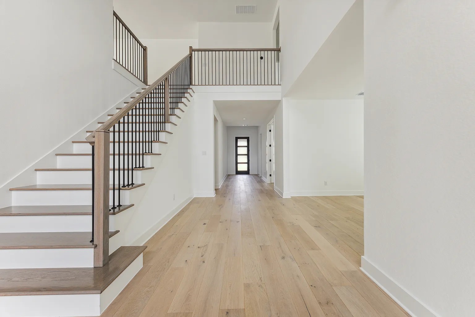 1909 Varese Path Leander, TX 78641 - Photo 4 of 40 A grand entry awaits with light hardwood flooring extending into a spacious hall and a sweeping staircase.