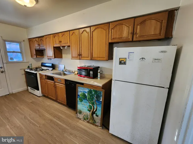 a kitchen with stainless steel appliances a refrigerator sink and wooden cabinets