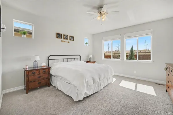 a spacious bedroom with a bed a dresser and next to a window