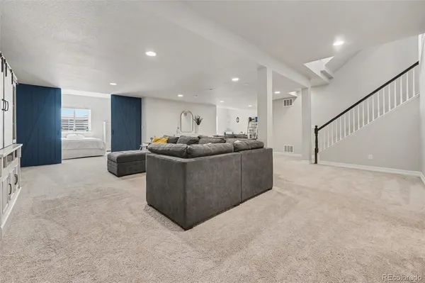 a living room with furniture a kitchen and a sink