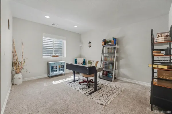 a view of a workspace with furniture and a window