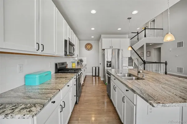 a kitchen with stainless steel appliances granite countertop a sink stove and cabinets