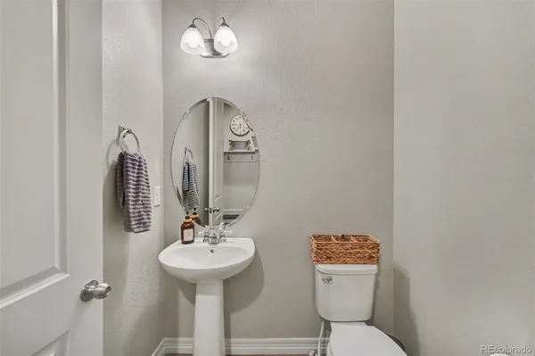 a bathroom with a toilet a sink and mirror
