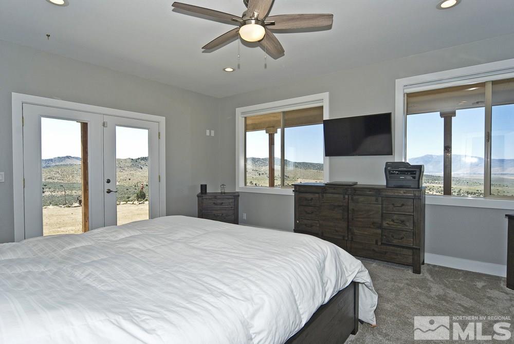 1375 Freds Mountain Road Reno, NV 89508 - Photo 13 of 40 a bedroom with a large bed and a chandelier