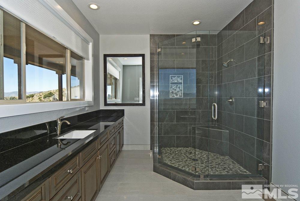1375 Freds Mountain Road Reno, NV 89508 - Photo 16 of 40 a bathroom with a double vanity sink a large mirror and shower